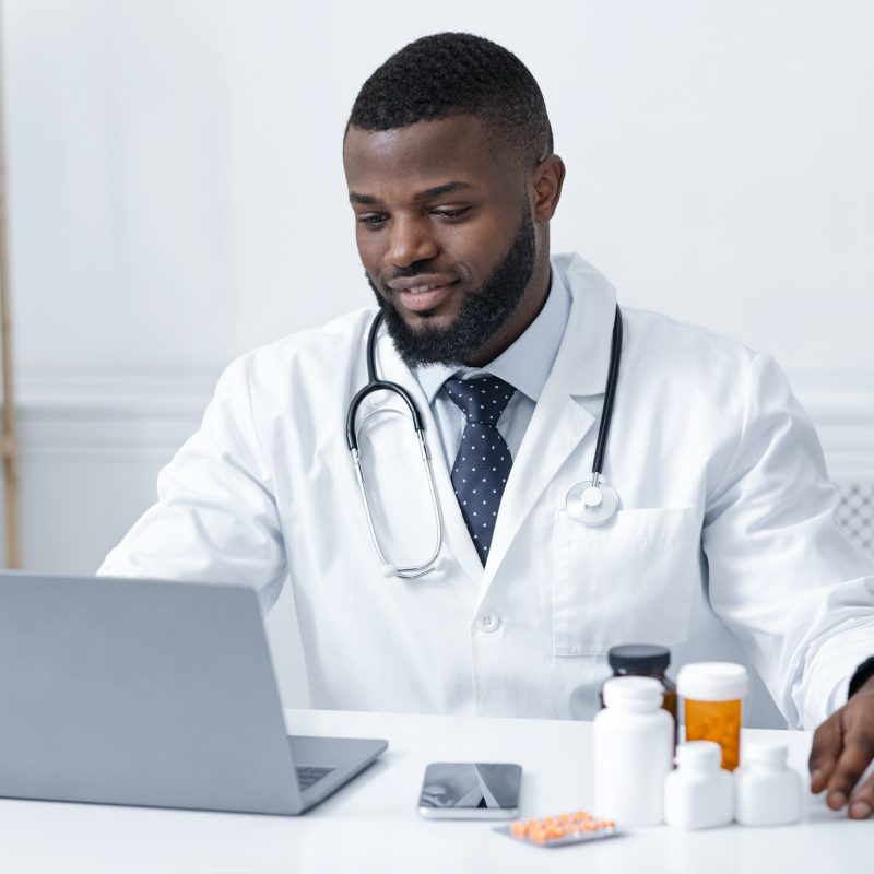 Concentrated african doctor checking on new pills