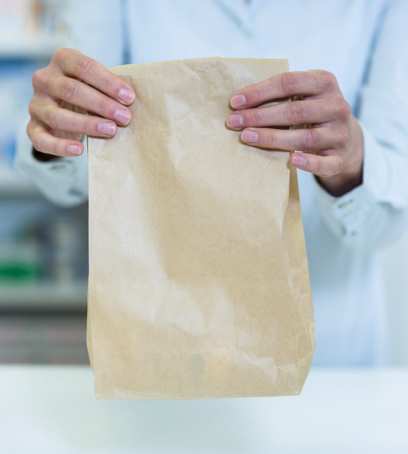 Pharmacist holding a medicine package in pharmacy